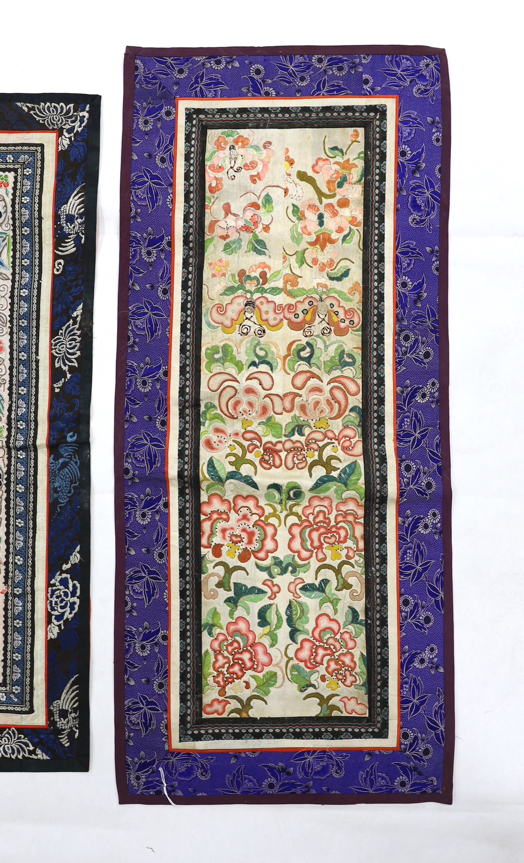 Three Beijing knot pairs of sleeve bands bordered with silk brocade and one pair embroidered with polychrome silks and gold thread longest, 73cm x 32cm including damask border